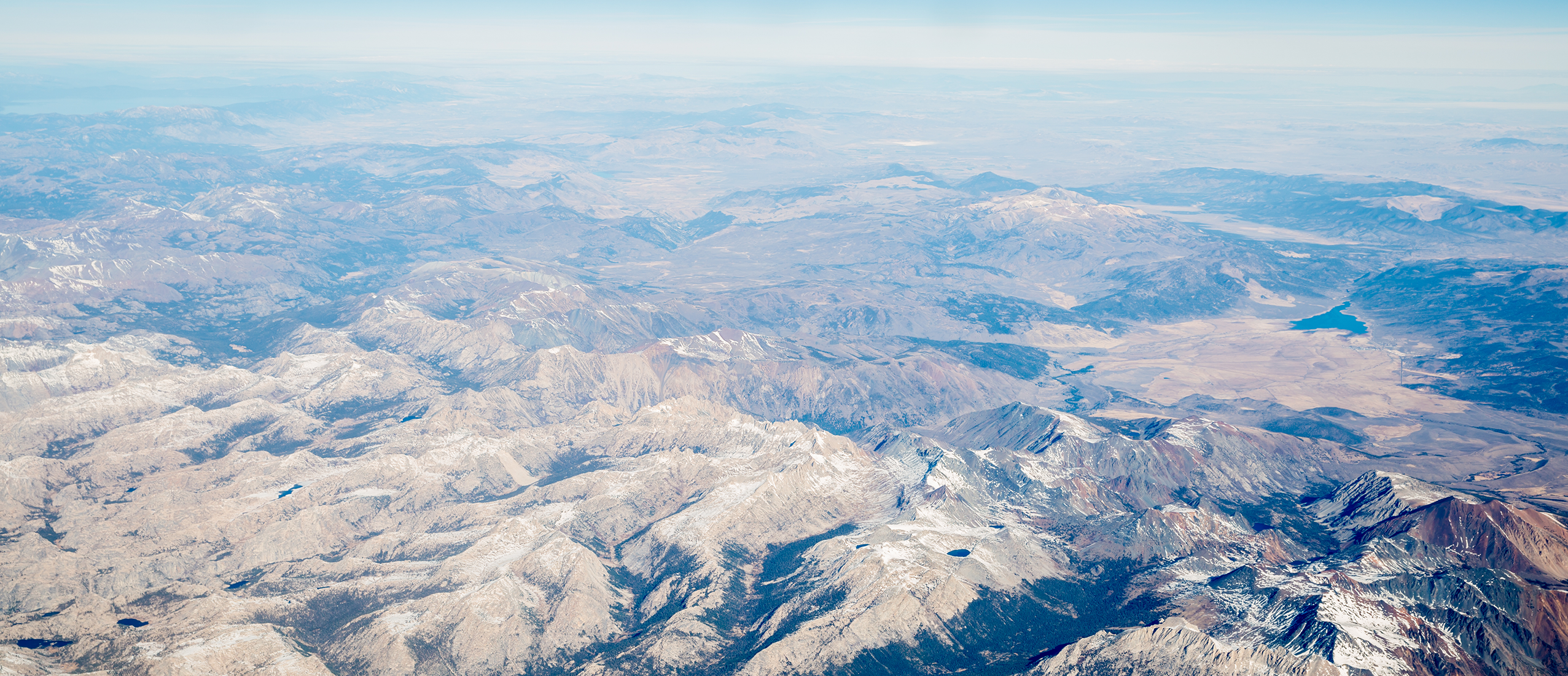 Sierra Nevada Mountians photographed from the sky stretching far into the horizon.