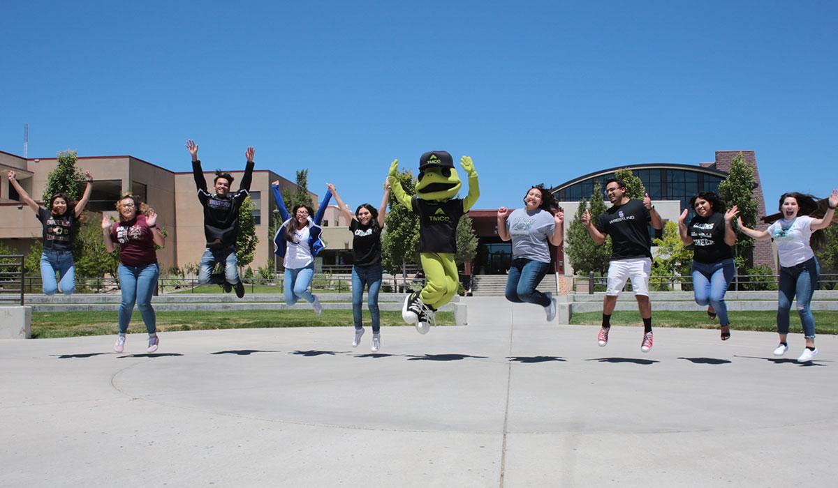 TMCC lizard mascot smiling and waving on campus
