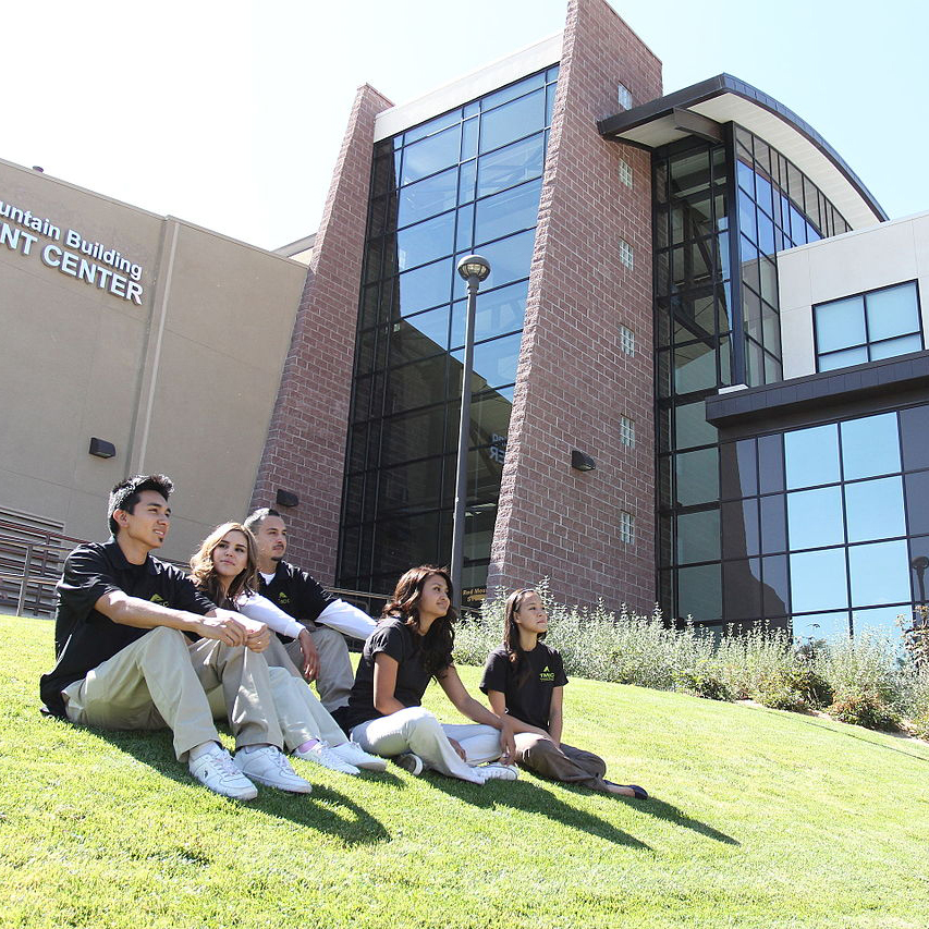 TMCC students sitting on campus in the grass