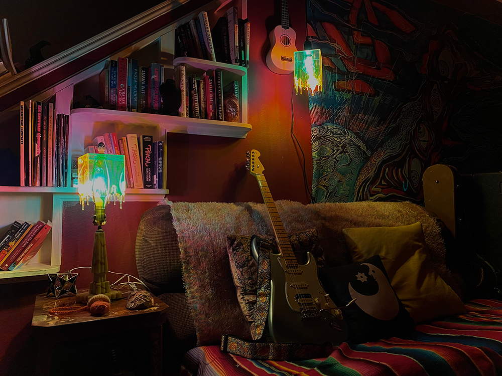 photograph of a well lit room with a guitar on the couch